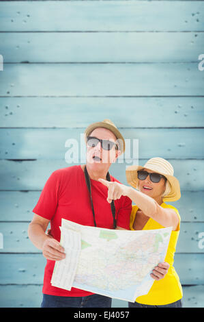 Immagine composita di felice turista giovane usando la mappa Foto Stock