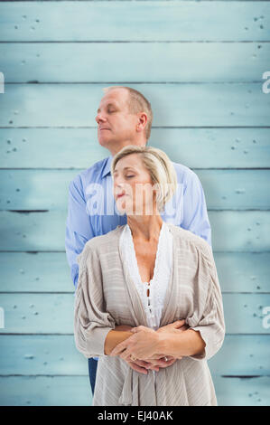 Immagine composita di felice coppia matura che abbraccia con gli occhi chiusi Foto Stock