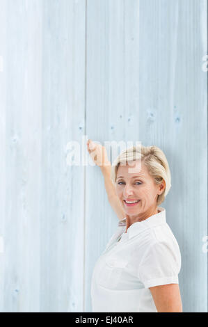 Immagine composita di felice donna matura la scrittura e sorridente Foto Stock