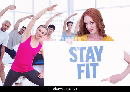 Immagine composita di pretty redhead che mostra un poster Foto Stock