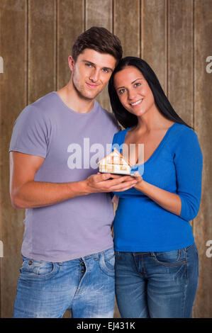 Immagine composita della coppia giovane tenendo un modello di casa Foto Stock