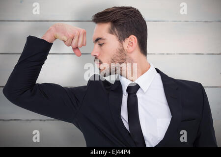 Immagine composita di allegro imprenditore braccio tensore muscolo Foto Stock