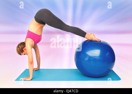 Immagine composita della vista laterale di montare una giovane donna stiramento sulla sfera di fitness Foto Stock