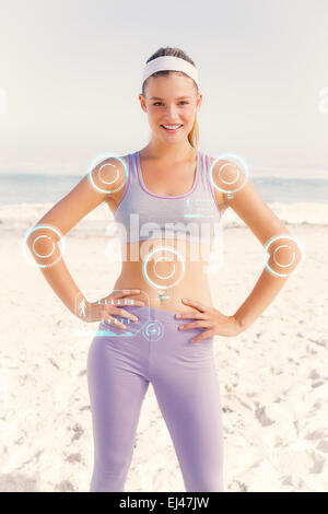 Immagine composita della bionda sportiva sulla spiaggia sorridente in telecamera Foto Stock