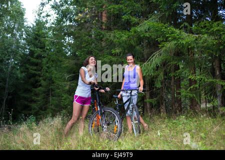 Due giovani donna graziosa e natura in bicicletta all'aperto Foto Stock