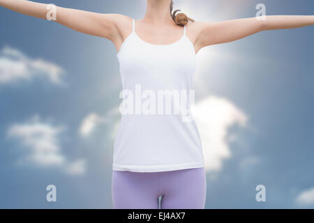 Immagine composita della donna in piedi con le braccia alzate sul paesaggio di campagna Foto Stock