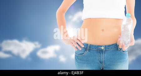 Immagine composita della sezione centrale di un accoppiamento donna tenendo una bottiglia di acqua Foto Stock