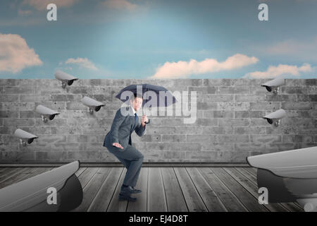 Immagine composita di imprenditore il ricovero sotto ombrellone nero Foto Stock