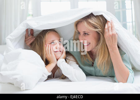 Madre e figlia guardando ogni altro sotto il piumino Foto Stock