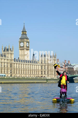 Hackney Monster Raving Loony candidato del partito, Nigel Knapp,sulla bicicletta galleggiante sul Tamigi di fronte alla Casa del Parlamento Foto Stock