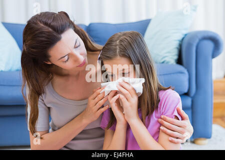 Madre aiutare mia figlia soffiare il naso Foto Stock