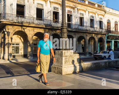 Un maschio anziano con capelli grigi passeggiate nella luce del mattino a l'Avana. Foto Stock