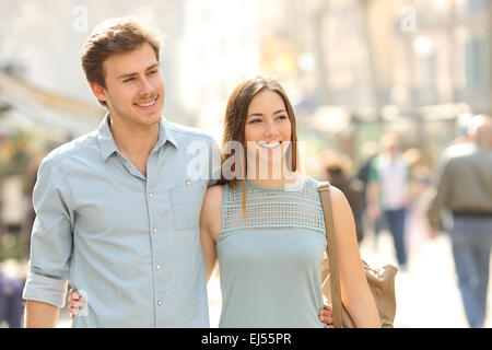 Coppia di turisti facendo una passeggiata in una strada di città marciapiede in una giornata di sole Foto Stock