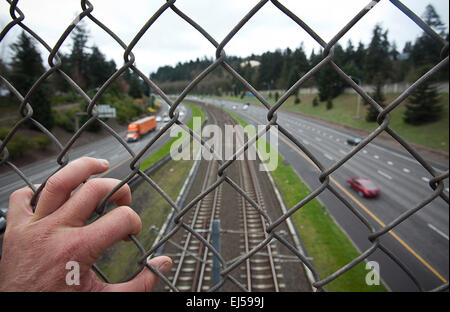 Portland, OR, Stati Uniti d'America. 26 Febbraio, 2015. Febbraio 26, 2015. Una catena collegamento recinto separa i pedoni dal treno e di " commuters " del veicolo il traffico sulla Interstate 205 a Portland, Oregon. © Ralph Lauer/ZUMA filo/Alamy Live News Foto Stock