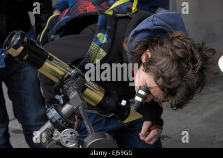 Un ragazzo sta cercando attraverso un telescopio amatoriale di osservare le eclissi solare attraverso la lente Barcelona Foto Stock