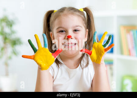 Bambina di cinque anni con le mani dipinte di vernici colorate Foto Stock