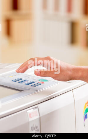 La mano di una persona utilizzando una macchina di copia Foto Stock