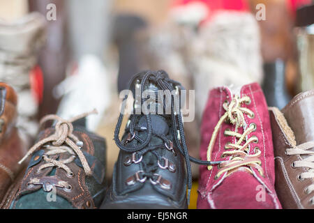 Una fila di vecchie scarpe su un mercato delle pulci, con retroilluminazione Foto Stock