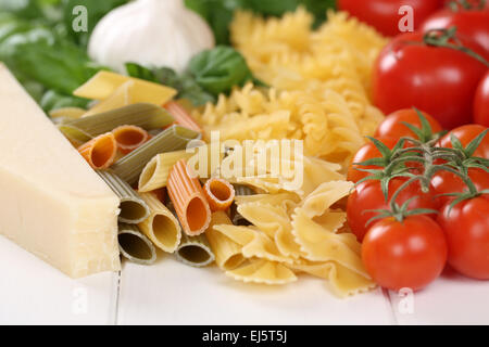 Ingredienti per la pasta di farina di tagliatelle con pomodori, penne, basilico e parmigiano Foto Stock