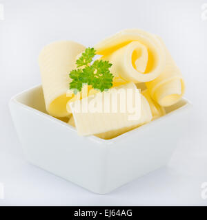 Riccioli di burro fresco su sfondo bianco Foto Stock