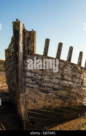 Una barca abbandonata su un argine Foto Stock