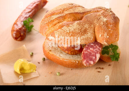 Il tedesco la salsiccia con bun e senape Foto Stock