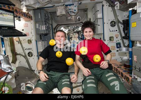 Noi astronauta Terry Virts e astronauta ESA Samantha Cristoforetti guarda le mele galleggiante durante una breve pausa dal lavoro a bordo della Stazione Spaziale Internazionale il 15 gennaio 2015 in orbita intorno alla terra. Foto Stock