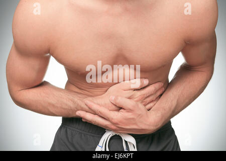 Giovane uomo che soffre di mal di stomaco Foto Stock