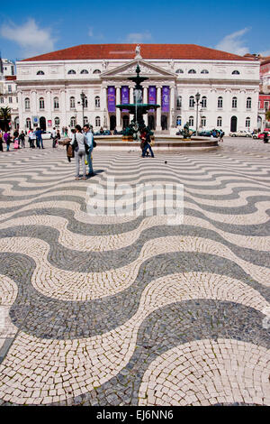 Pavimentazione ondulata di piastrelle portoghesi a Lisbona la Piazza Rossio con Dona Maria II Teatro Nazionale e fontana barocca. Foto Stock