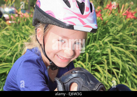 Bambina con pattini a rotelle in un parco Foto Stock