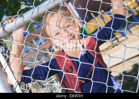 Un sorridente bambina a scuola parco giochi Foto Stock