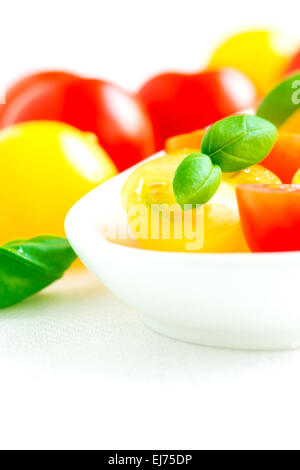 Un assortimento di colorata di rosso e di giallo pomodori ciliegia nella piastra close up Foto Stock