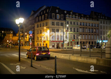 Attraversamento di strada, auto, semafori, Quai des Bateliers quay edifici di notte Strasburgo Alsace Francia Europa Foto Stock