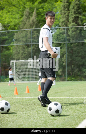 I giovani allenatori di calcio nel campo sportivo Foto Stock