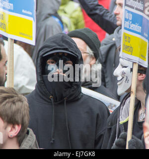 Piccadilly Circus, Londra UK - Marzo 21st 2015: Vestito di nero un protester mascherato nella folla alla manifestazione Stand Up to Racism & fascism. Foto Stock