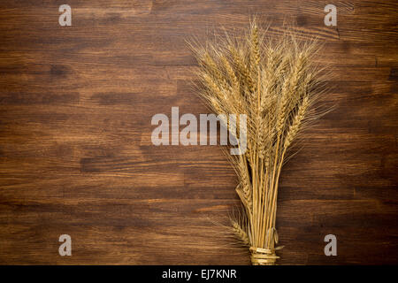 Spighe di grano sul tavolo di legno. Un covone di grano su legno. Concetto di raccolto Foto Stock