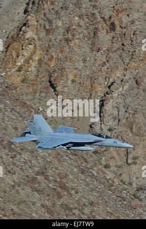 Close up di un US Navy F/A-18E Super Hornet jet fighter volando a bassa quota lungo un canyon del deserto. Foto Stock