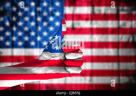 Mano con pollice su coperte di bandiera americana. Foto Stock