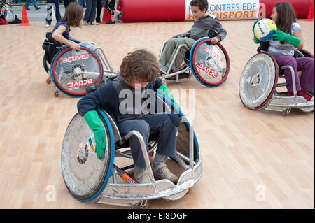 Parigi, FRANCIA - Francese Bambini disabili in sedia a rotelle gioco di pallacanestro al 'Rencontres EDF Handisport'. Esigenze speciali esercizio, insegnamento di sport per i bambini Foto Stock