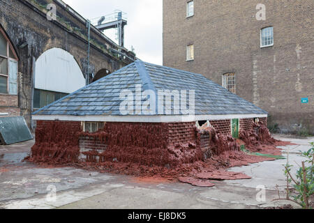 Casa di fusione da Alex Chinneck 40 Southwark St, London, SE1. Illustrazione di cera e riscaldata lentamente a sciogliersi nel tempo Foto Stock