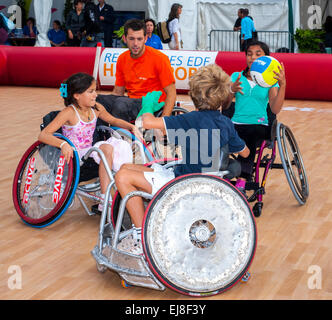 Parigi, FRANCIA - Bambini francesi disabili in carrozzina che giocano insieme all'insegnante nella classe di pallacanestro a Parigi 'Rencontres EDF Handisport'. Sport esigenze speciali esercizio, insegnamento dello sport ai bambini, gioco all'aperto, sport all'aperto per ragazzi e ragazze, Fitness Foto Stock