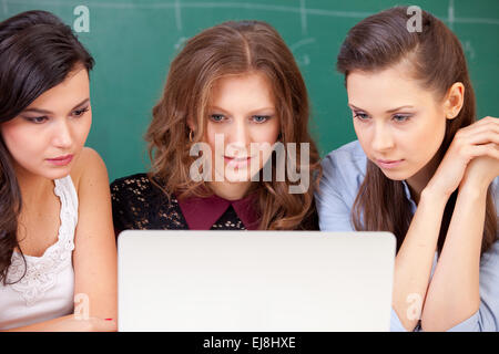 Tre studenti e un notebook Foto Stock