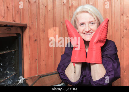 Senior donna i biscotti di cottura sul fornello Foto Stock