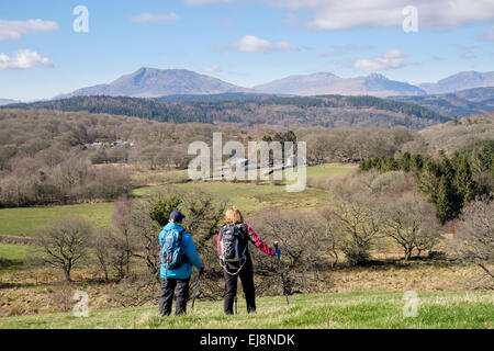 Due escursionisti alla ricerca di una vista sulle montagne del Parco Nazionale di Snowdonia in distanza. Capel Garmon, Conwy, il Galles del Nord, Regno Unito, Gran Bretagna Foto Stock