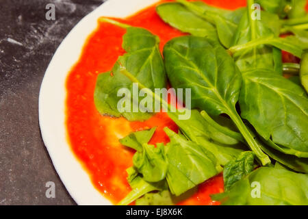 Materie pizza con spinaci e salsa di pomodoro Foto Stock