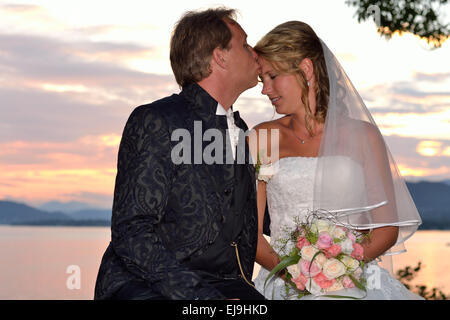 Lo sposo baci la sposa al lago Foto Stock