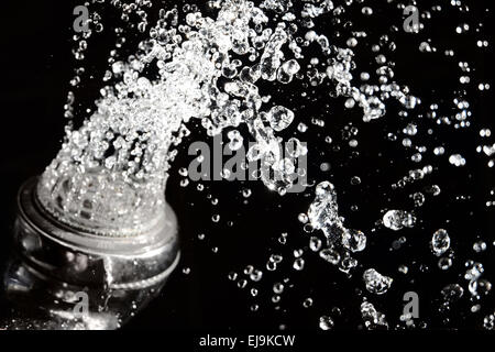 Testa di doccia con acqua sul nero. Foto Stock