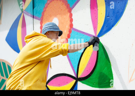 Focalizzato giovane pittura graffiti sulla parete Foto Stock