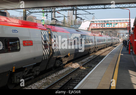 Macclesfield Stazione ferroviaria piattaforme su una soleggiata giornata di primavera. Un treno da Londra è in piedi accanto alla piattaforma. Foto Stock