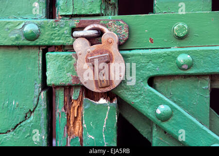 Un lucchetto su un di legno verniciato di verde porta del granaio. Foto Stock